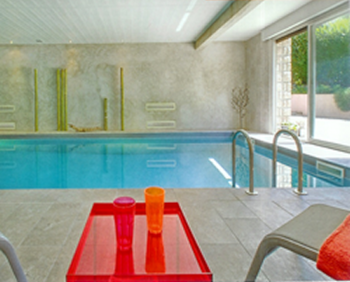 ultra modern indoor pool with marble wall finishes